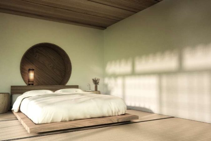 Une chambre en véritable espace zen avec un lit bas en bois, une décoration circulaire murale et une ambiance épurée inspirée du style japonais.
