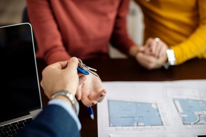 Remise des clés d'un logement à un couple après une évaluation réussie sur un outil estimation prix immobilier gratuit.